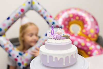 Close-up of cake with girl in background