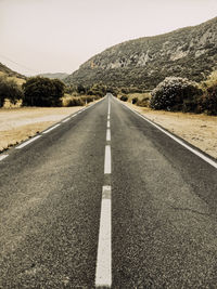 Surface level of empty road against mountain