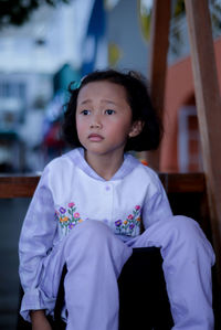 Portrait of cute girl sitting on chair