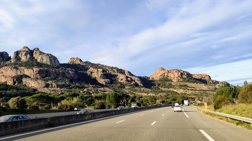 Road by mountain against sky