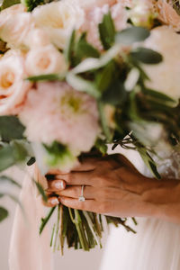 Midsection of bride holding bouquet