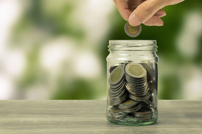 Close-up of hand holding jar against blurred background