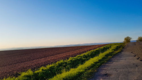 Scenic view of field against clear blue sky