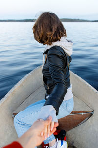 Side view of woman sitting in boat at lake