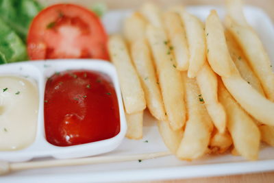 Close-up of french fries with tomato sauce in plate