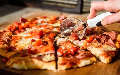 Close-up of hand holding pizza