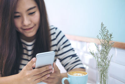 Woman using phone at cafe