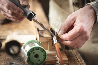 Close-up of man working on wood at workshop