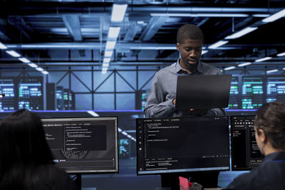 Side view of businessman using laptop at airport