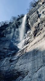 Low angle view of waterfall against sky