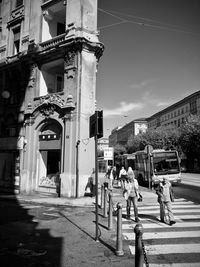 People walking on street amidst buildings in city