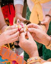 Midsection of people performing traditional ritual outdoors