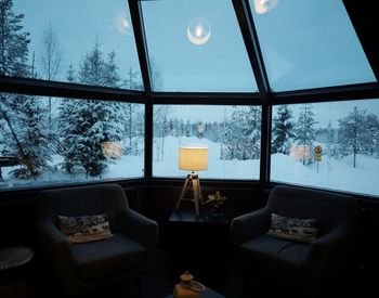 Illuminated electric lamp on table by window