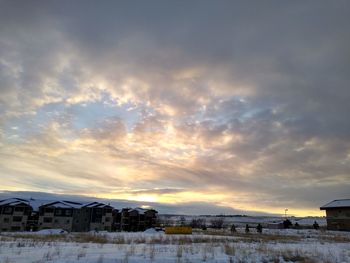 Houses by buildings against sky during winter