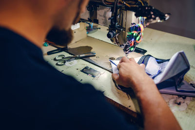 High angle view of man working on sewing machine