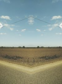 Scenic view of field against cloudy sky