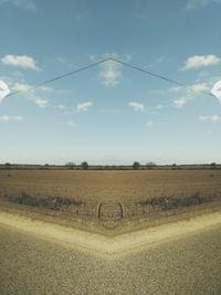 Scenic view of field against cloudy sky