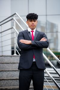 Full length of a young man standing against wall