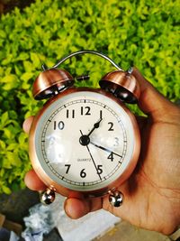 Close-up of hand holding clock