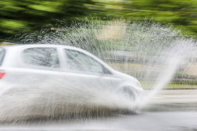 Car splashing water on road