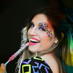 Portrait of happy woman holding flavored ice with candy sprinkles make-up