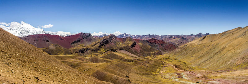 Scenic view of mountains against blue sky