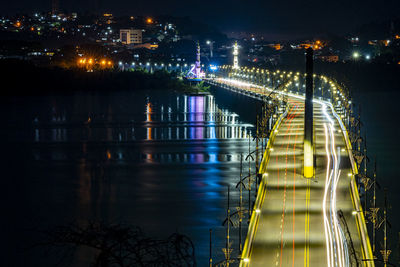 Illuminated dompak bridge over river at night