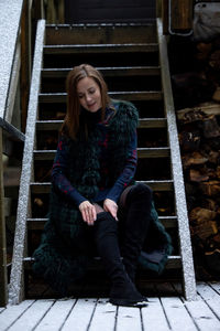 Portrait of young woman sitting on staircase