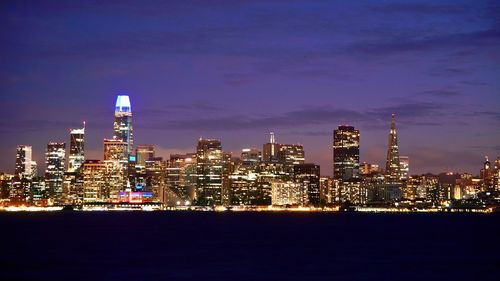 Illuminated buildings against sky at night