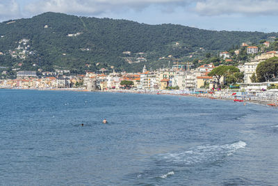 Scenic view of sea by buildings in city