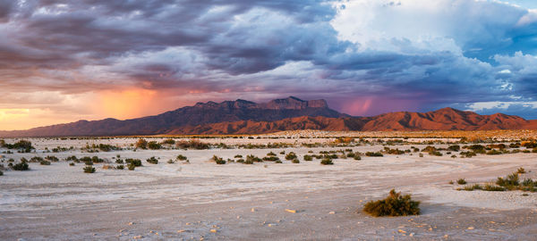 Panoramic view of land and mountains against sky during sunset