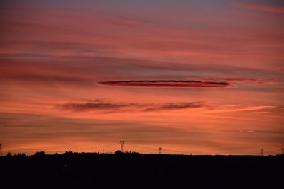 Silhouette landscape against dramatic sky during sunset