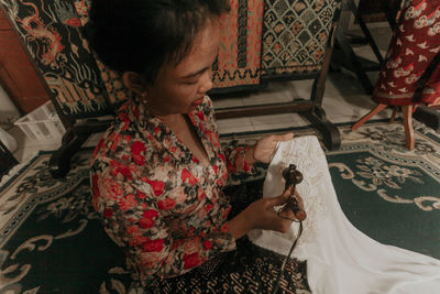 High angle view of woman holding camera at home