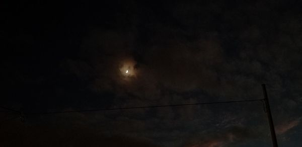 Low angle view of silhouette cables against sky at night