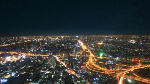 High angle view of illuminated city against sky at night