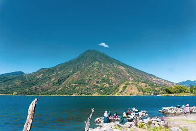 Scenic view of sea and mountains against blue sky