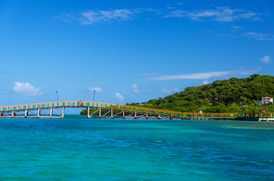 Bridge over sea against blue sky