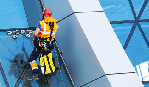 Window cleaner working on a glass facade modern skyscraper