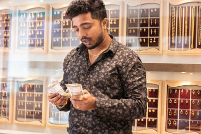 Man counting banknotes in jewelry store