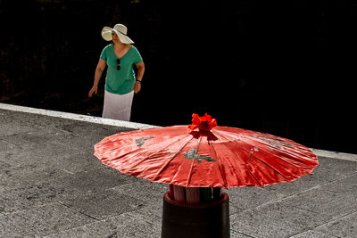 Rear view of man holding red umbrella