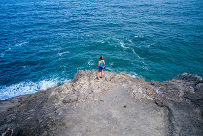 High angle view of man on rocks at sea shore