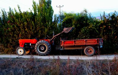 Side view of tractor on field against sky