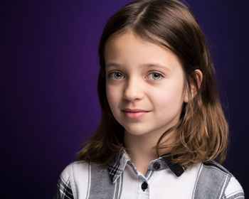 Portrait of smiling girl against purple background