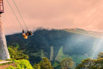 Overhead cable car over mountains against sky