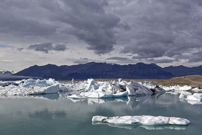 Scenic view of frozen lake against cloudy sky