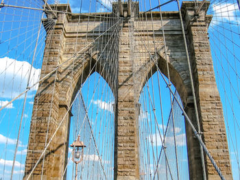 Low angle view of suspension bridge against blue sky