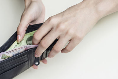 Midsection of woman holding hands over white background
