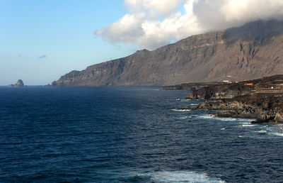 Scenic view of sea and mountains against sky