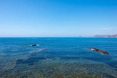 Scenic view of sea against clear blue sky