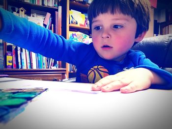 Portrait of boy with book on table